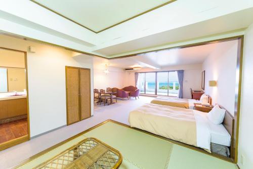 a hotel room with a bed and a bathroom at Kanehide Onna Marine View Palace in Onna
