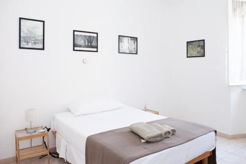 a white bedroom with a bed and a table at Residenza Cleopatra 1 in Ancona