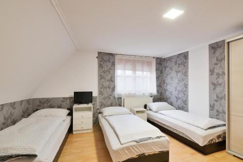 a bedroom with three beds and a window at Micófogadó in Budapest