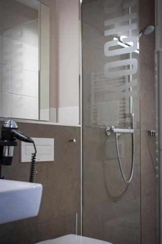 a shower in a bathroom with a glass door at Kochs Stadthotel in Olpe