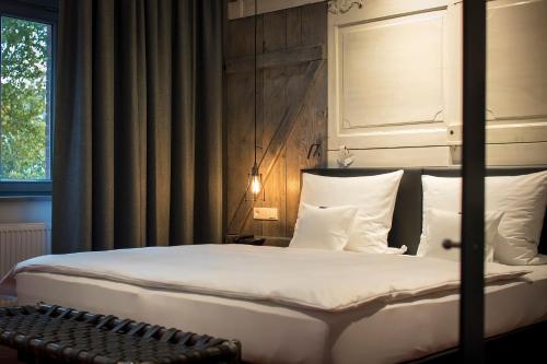 a bedroom with a bed with white sheets and pillows at Kochs Stadthotel in Olpe