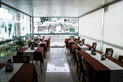 a restaurant with tables and a horse statue in the background at Dalle Hotel in Bagé