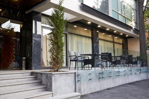 a building with a table and chairs outside of it at Best Western Tbilisi City Center in Tbilisi City