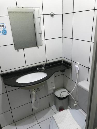 a bathroom with a sink and a toilet and a mirror at Hotel Monólitos in Quixadá