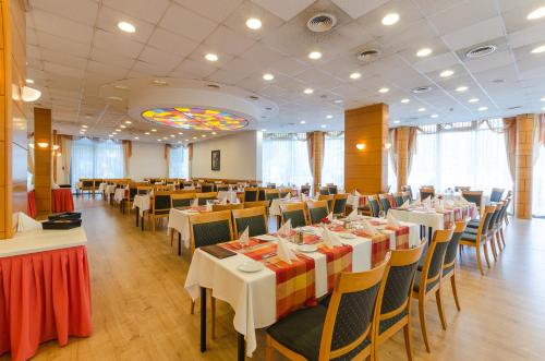 a dining room with tables and chairs and a room with at Hunguest Hotel Aqua Sol in Hajdúszoboszló