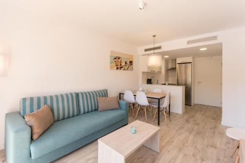 a living room with a blue couch and a table at Pierre & Vacances Estartit Playa in L'Estartit