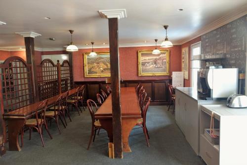 une salle à manger avec des tables et des chaises ainsi qu'une cuisine dans l'établissement Fasthotel Bordeaux Eysines, à Eysines