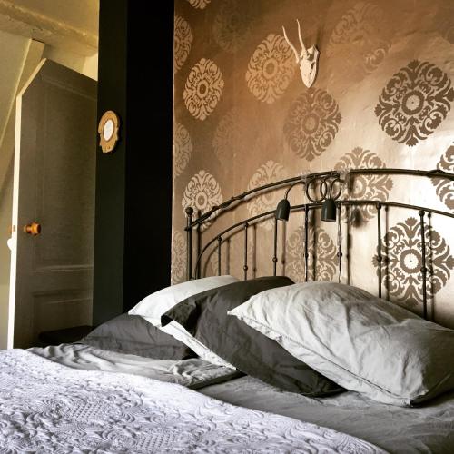 a bedroom with a bed with a metal head board at B&B Het Rode Hert in Doesburg