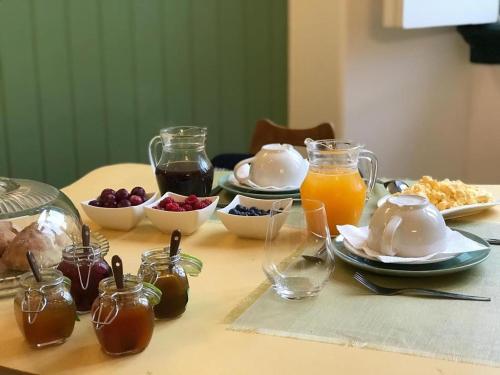 科英布拉Oryza Guest House& Suites的餐桌上摆放着早餐食品和果汁