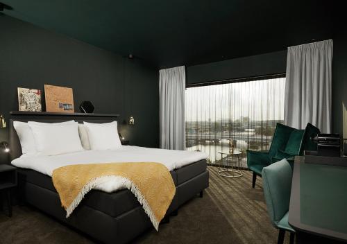 een slaapkamer met een groot bed en een groot raam bij Van der Valk Hotel Amsterdam - Amstel in Amsterdam