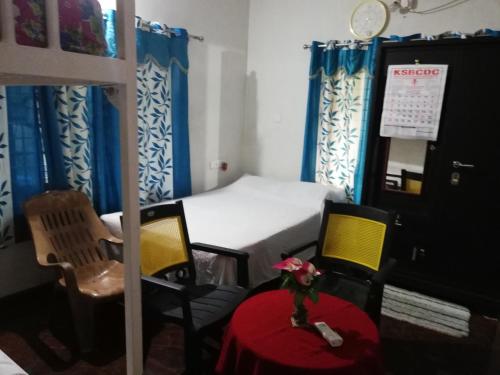 a bedroom with a bed and a table and chairs at Takashi Homestay North Paravur Near Muziris in North Paravur
