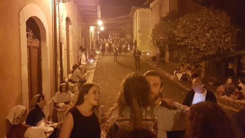un grupo de personas sentadas en una calle por la noche en Scaccia pensieri, en Cerchio