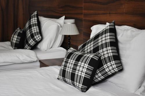 two black and white pillows sitting on a bed at Argyll Guest House in Glasgow