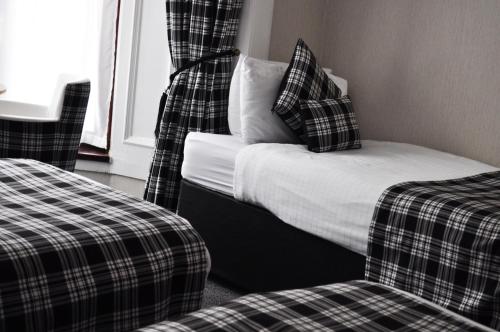 a bedroom with a bed and two chairs and a window at Argyll Guest House in Glasgow