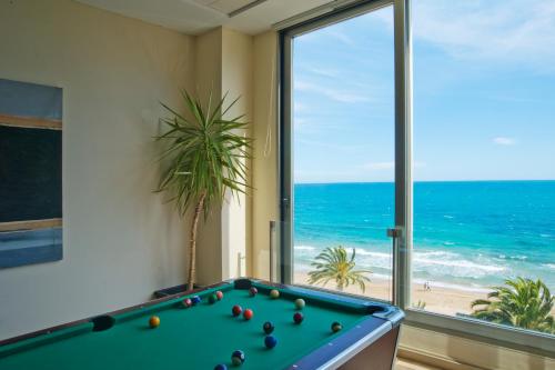 a pool table in a room with a view of the beach at Hotel Bahía Calpe by Pierre & Vacances in Calpe