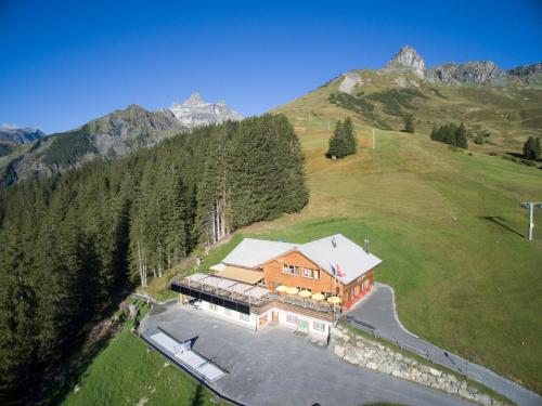 an aerial view of a house on a hill with mountains at Bischofalp in Elm