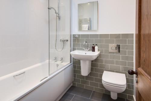 a bathroom with a sink and a toilet and a shower at Wagtail Cottage in Berwick-Upon-Tweed