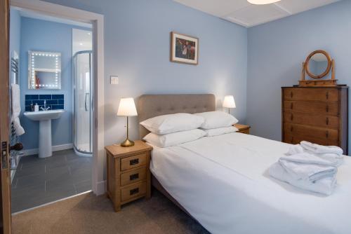 a bedroom with a large white bed and a sink at Wagtail Cottage in Berwick-Upon-Tweed