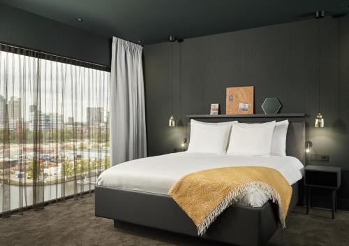 a bedroom with a large bed and a large window at Van der Valk Hotel Amsterdam - Amstel in Amsterdam