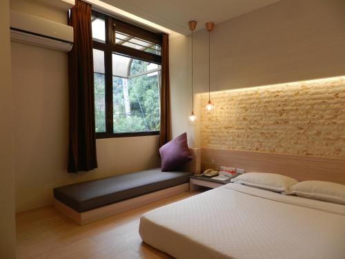 1 dormitorio con cama y ventana con banco en 谷關明高溫泉 Mingao Hot Spring Resort en Heping