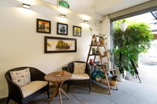 a room with two chairs and a table and a ladder at Sen Boutique House By 5H in Ho Chi Minh City