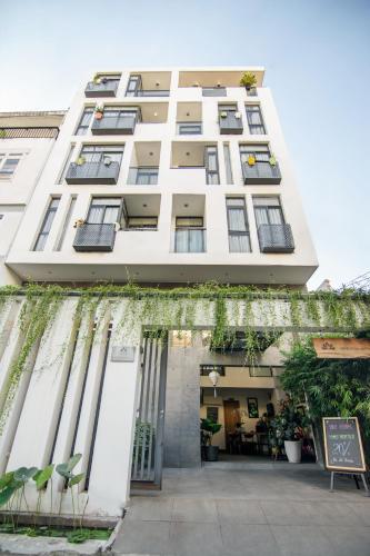 a large white building with plants on the facade at Sen Boutique House By 5H in Ho Chi Minh City