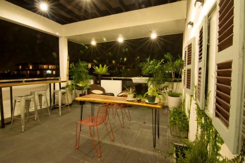 a patio with a table and chairs and plants at Sen Boutique House By 5H in Ho Chi Minh City