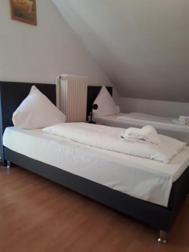 2 camas con sábanas blancas y almohadas en una habitación en Hotel Taverne Inos en Hannover