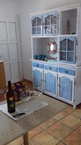 テギセにあるCasa Frascaのキッチン(青いキャビネット、ワイングラス付きのテーブル付)