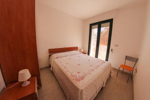 Habitación pequeña con cama y ventana en ARIES Case Vacanza, en Marina di Mancaversa