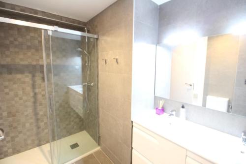 y baño con ducha acristalada y lavamanos. en Apartamento Playa Fontanilla, en Marbella