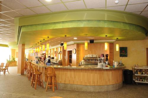 a restaurant with a bar with stools and a counter at Hotel La Rápita in Sant Carles de la Ràpita