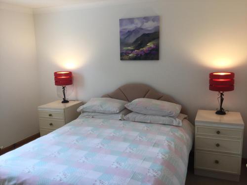 a bedroom with a bed with two lamps on it at Two-Bedroom Apartment - Golf View Free Parking in Inverness