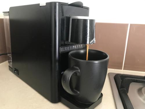 a coffee maker pouring coffee into a cup on a counter at Couple's Luxury Resort Spa Retreat in Cowes