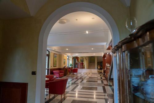 an archway leading to a hallway with chairs and tables at Hotel Villa Venus Resort & SPA in Atena Lucana