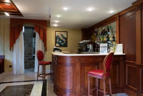 a bar with red stools in a room at Hotel Villa Venus Resort & SPA in Atena Lucana