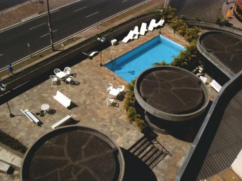 una vista aérea de una piscina con mesas y sillas en Obeid Plaza Hotel, en Bauru