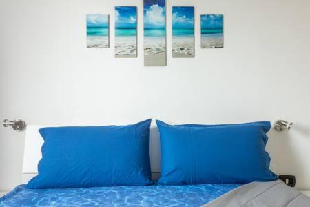 a bed with blue pillows in a bedroom at B&B Italia in Milis