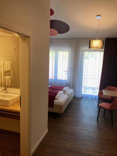 a hotel room with a bed and a bathroom at Busses Guesthouse in Freiburg im Breisgau