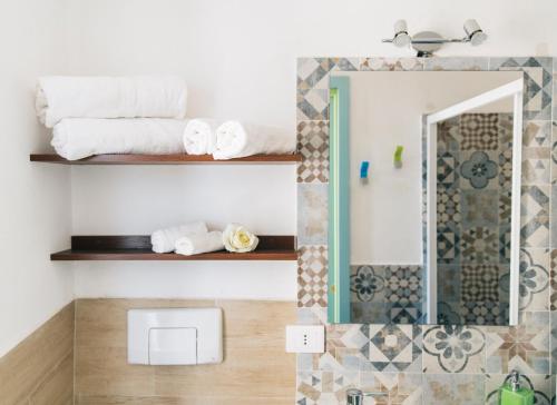 bagno con asciugamani bianchi e specchio di Perla Del Borgo Bed and Breakfast a Santa Caterina dello Ionio