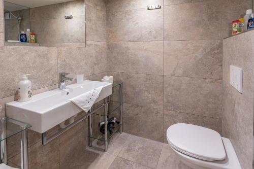 a bathroom with a white sink and a toilet at Ferienwohnung Metzler - Blick auf die Berge in Göfis
