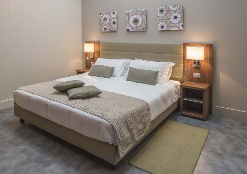 a bedroom with a large bed with two pillows on it at Hotel La Falaise Bonapriso in Douala