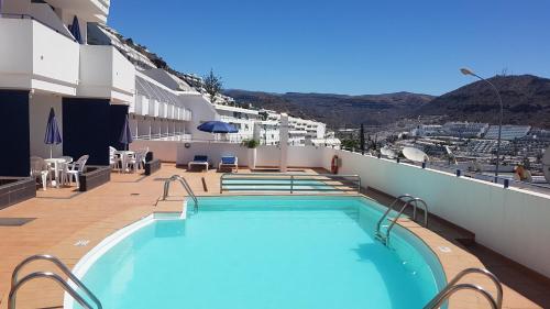 a swimming pool on the roof of a hotel at Apartamentos Isla Bonita in Puerto Rico de Gran Canaria