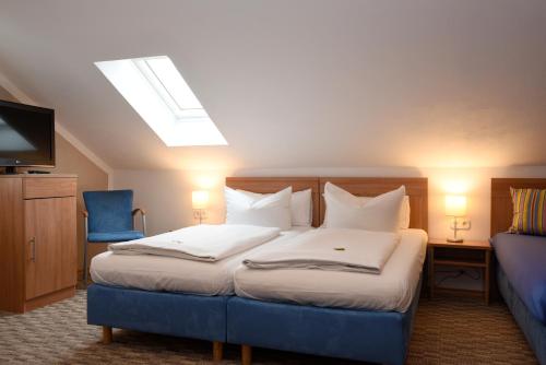 Hotel Hecht Garni في إنغولشتات: غرفة نوم بسرير كبير وكرسي ازرق