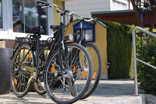 due biciclette parcheggiate l'una accanto all'altra su un marciapiede di Hotel Hecht Garni a Ingolstadt