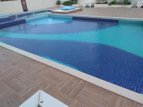 una piscina con acqua blu e pavimento in legno di Estrela do Mar a Florianópolis