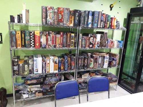 a book shelf filled with dvds and books at D-Toys Homestay in Khon Kaen