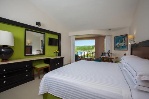 a bedroom with a white bed and a green wall at Barceló Huatulco in Santa Cruz Huatulco