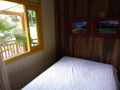 a bedroom with a bed and two windows at Recanto na Montanha de Gramado in Gramado
