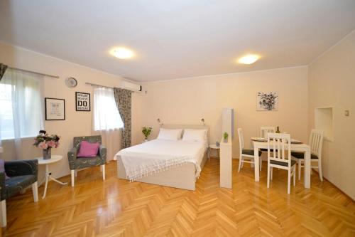 Schlafzimmer mit einem Bett, einem Tisch und Stühlen in der Unterkunft Apartment Filip in Kotor